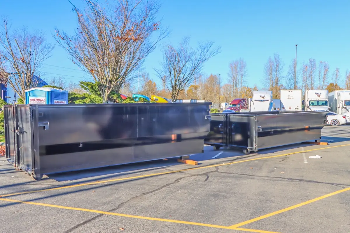 Professional dumpster rental service with roll-off container on residential driveway in Brick